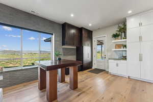 Kitchen with light wood-style floors, decorative backsplash, open shelves, recessed lighting, and white cabinets