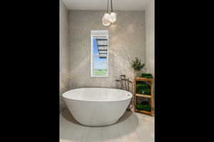 Full bath featuring tile patterned floors and a soaking tub