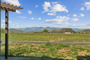 View of mountain backdrop with rural landscape and a pastoral area