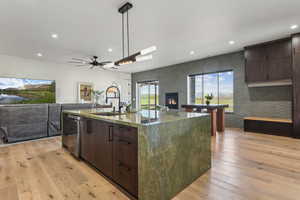 Kitchen featuring open floor plan, a sink, dark brown cabinetry, recessed lighting, and a ceiling fan
