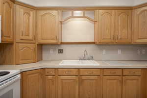 Kitchen with a sink, light countertops, and electric stove