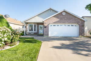 Ranch-style home with brick siding, driveway, and an attached garage