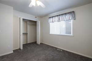 Unfurnished bedroom featuring carpet, a closet, baseboards, and ceiling fan
