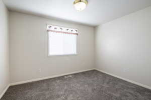Carpeted empty room featuring baseboards