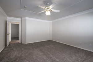 Carpeted spare room with a ceiling fan, ornamental molding, a smoke detector, and baseboards