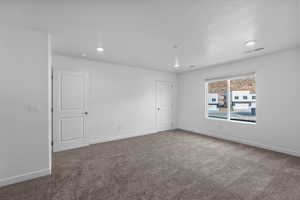 Carpeted empty room featuring baseboards and recessed lighting