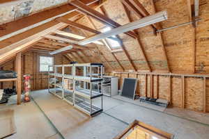 Unfinished attic featuring a skylight
