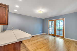 Unfurnished dining area featuring light wood-style flooring, baseboards, and recessed lighting