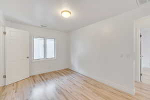 Unfurnished room featuring light wood finished floors and baseboards