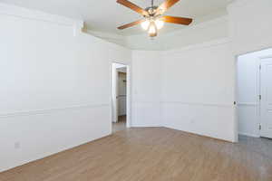 Unfurnished room featuring light wood-type flooring, ceiling fan, and baseboards