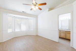 Unfurnished room with lofted ceiling, light wood-style floors, ceiling fan, a sink, and baseboards