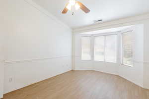Empty room with light wood-style flooring, baseboards, and a ceiling fan