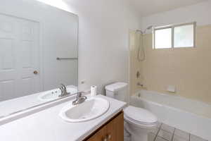 Full bathroom featuring vanity, shower / bath combination, and tile patterned flooring