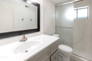 Bathroom featuring vanity, a marble finish shower, and marble look tile flooring