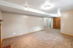 Finished below grade area featuring carpet floors and a textured ceiling