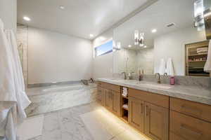 Bathroom with marble finish floors, a bath, double vanity, recessed lighting, and a shower