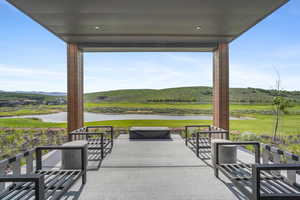 View of patio / terrace featuring a water and mountain view and view of golf course