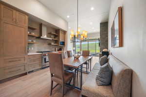 Dining space featuring light wood-style floors, recessed lighting, and a chandelier