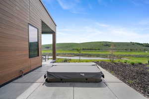 View of patio / terrace featuring a covered hot tub and a water view