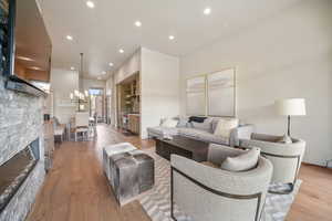 Living room featuring light wood-style floors, recessed lighting, and a fireplace