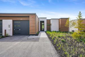 Contemporary house featuring asphalt driveway and a garage