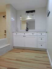 View of large vanity in basement bathroom with jetted tub