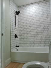 Hall bathroom with tub / shower combination and wood finished floors