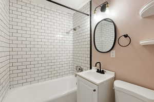 Bathroom with toilet, vanity, and shower / bath combination