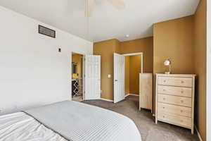Carpeted bedroom featuring a ceiling fan and baseboards