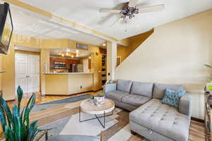Living room with light wood finished floors, ceiling fan, and baseboards