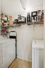 Washroom with separate washer and dryer, light tile patterned flooring, and baseboards