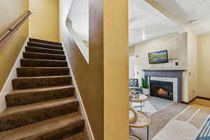 Stairs with a fireplace and baseboards