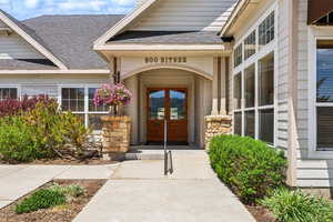 Doorway to property featuring a shingled roof