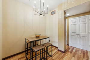 Dining area featuring light wood-type flooring, a chandelier, and baseboards