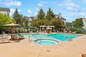 Community pool with a hot tub, a pergola, and a patio