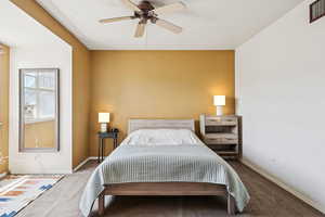 Carpeted bedroom featuring baseboards and a ceiling fan