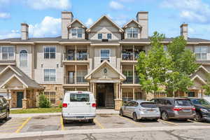 View of building exterior featuring uncovered parking