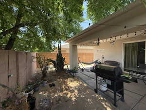 Fenced backyard featuring a patio and grilling area