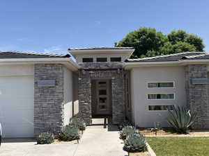 Entrance to property featuring stone siding and stucco siding