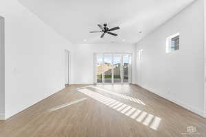 Unfurnished room with baseboards, light  LVP floors, and ceiling fan