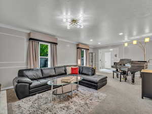Living area featuring ornamental molding, light carpet, baseboards, and recessed lighting