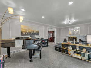 Dining space with crown molding, carpet flooring, a fireplace, and recessed lighting