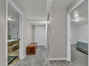 Corridor featuring carpet flooring and baseboards