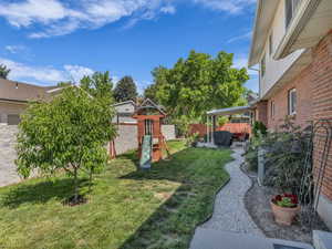 View of yard with a playground and a patio