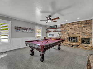 Recreation room featuring carpet floors, a ceiling fan, pool table, ornamental molding, and wainscoting