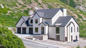 View of front of house with driveway, stucco siding, roof with shingles, a garage, and central AC unit