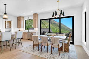 Dining space featuring light wood finished floors, recessed lighting, a chandelier, a mountain view, and baseboards