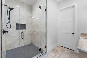 Full bath featuring a stall shower, marble finish floors, and vanity