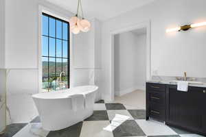 Bathroom featuring vanity, a freestanding bath, and marble tiled floors