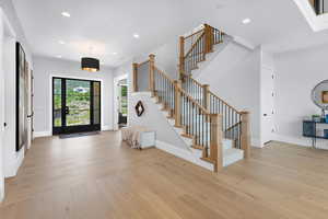 Entrance foyer featuring light wood-style floors, stairs, baseboards, and recessed lighting